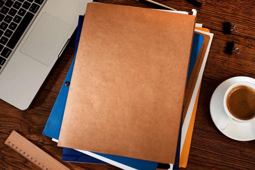 foldre na stole s kávou, laptopom a kancelárskymi potrebami